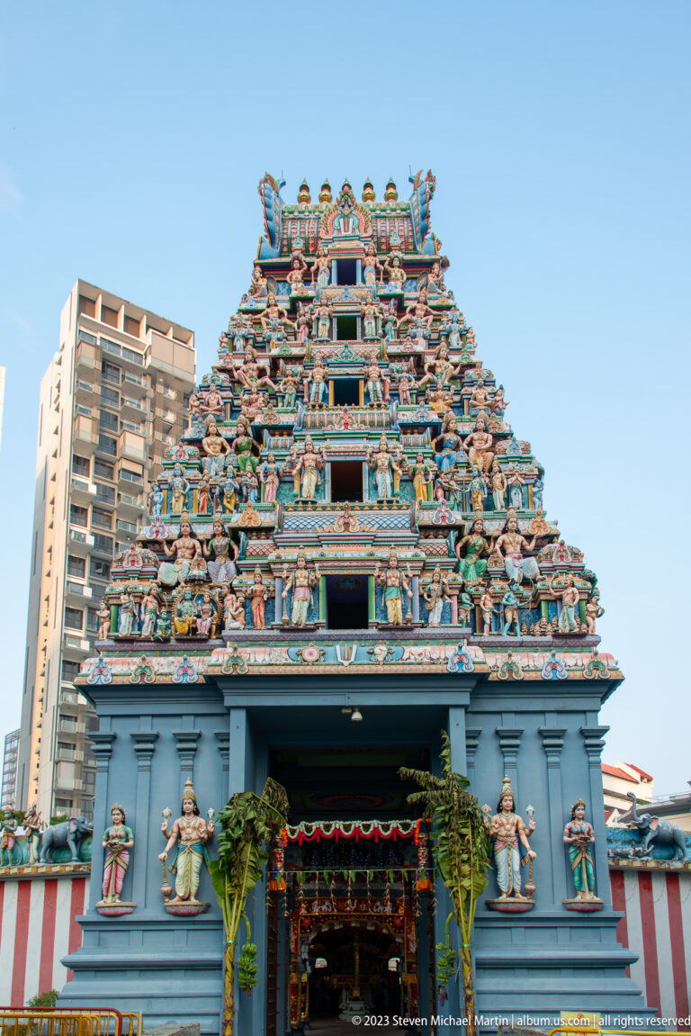 Frontal view of Sri Srinivasa Perumal Temple with blue-gray entrance and richly sculpted gopuram.