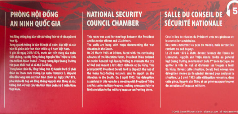 Red multilingual wall panel titled National Security Council Chamber with explanatory historical text.