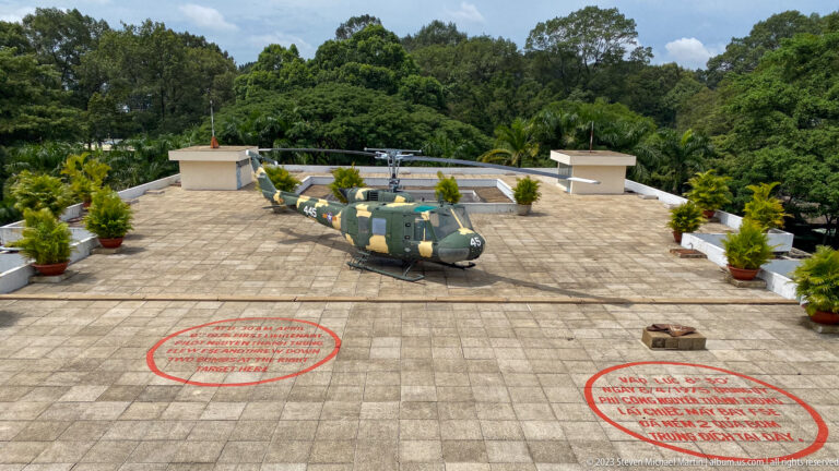 Bell UH-1 helicopter on the palace roof beyond two red circles marking bomb impact locations.