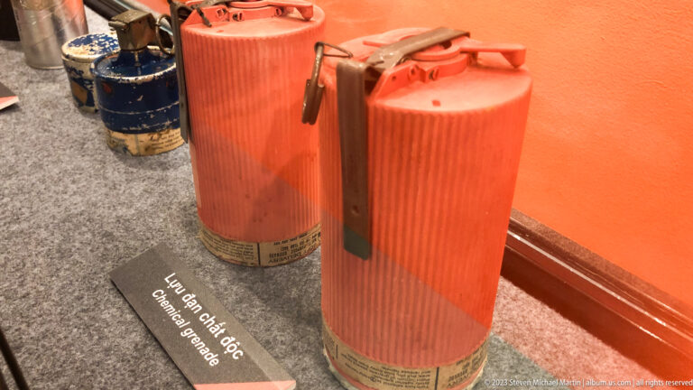 Three tall orange ribbed canisters with handles and caps.