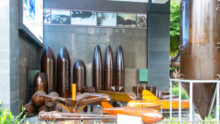 Large aerial bombs and assorted ordnance arranged in an outdoor museum display.
