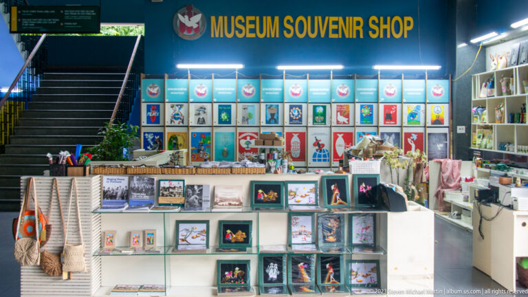 Museum souvenir shop with books, bags, postcards, and colorful merchandise.