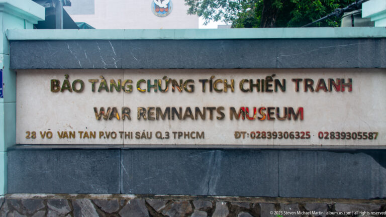 Stone entrance sign reading “War Remnants Museum” in Vietnamese and English.