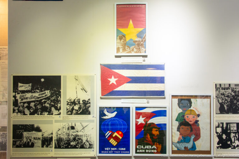 Cuban flags, solidarity posters, and archival photographs on a museum wall.