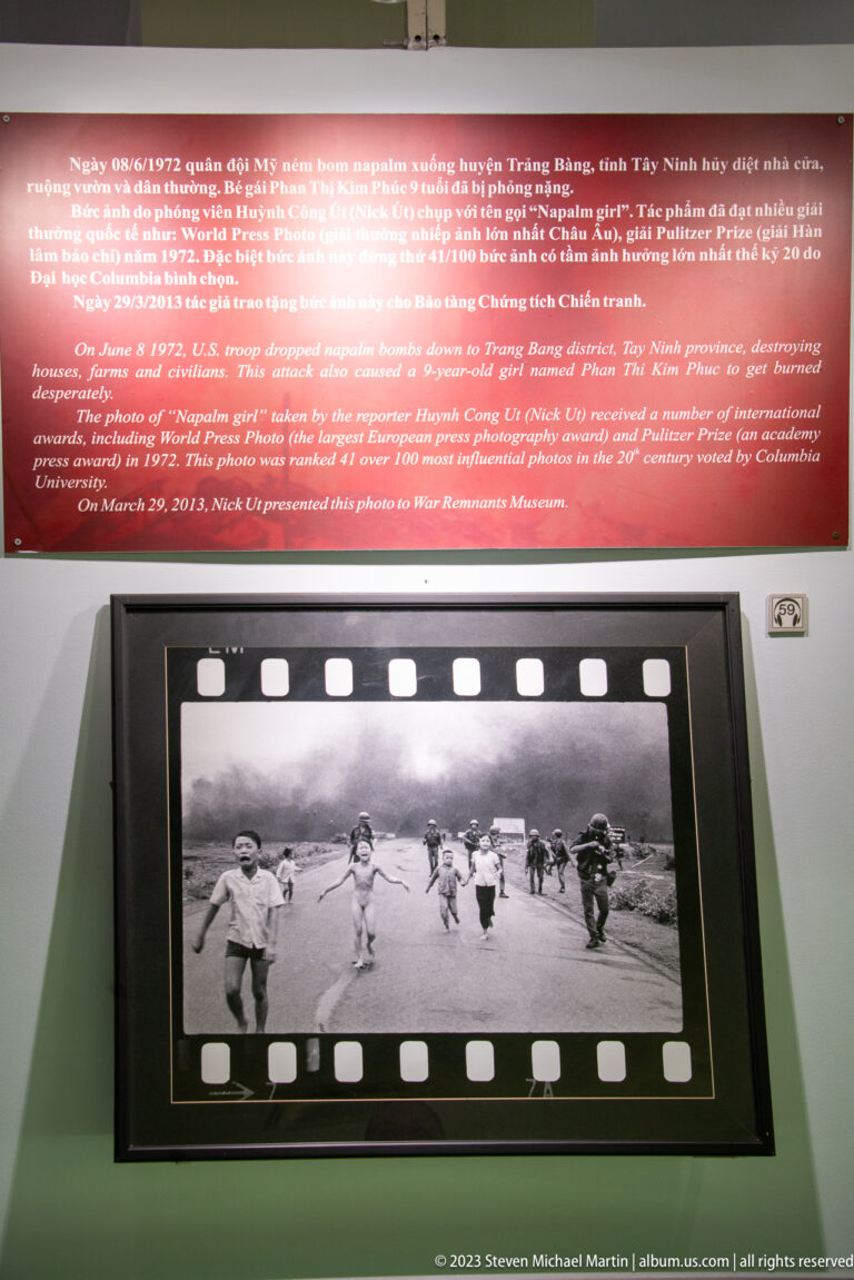 Red museum panel above a framed black-and-white wartime photograph.