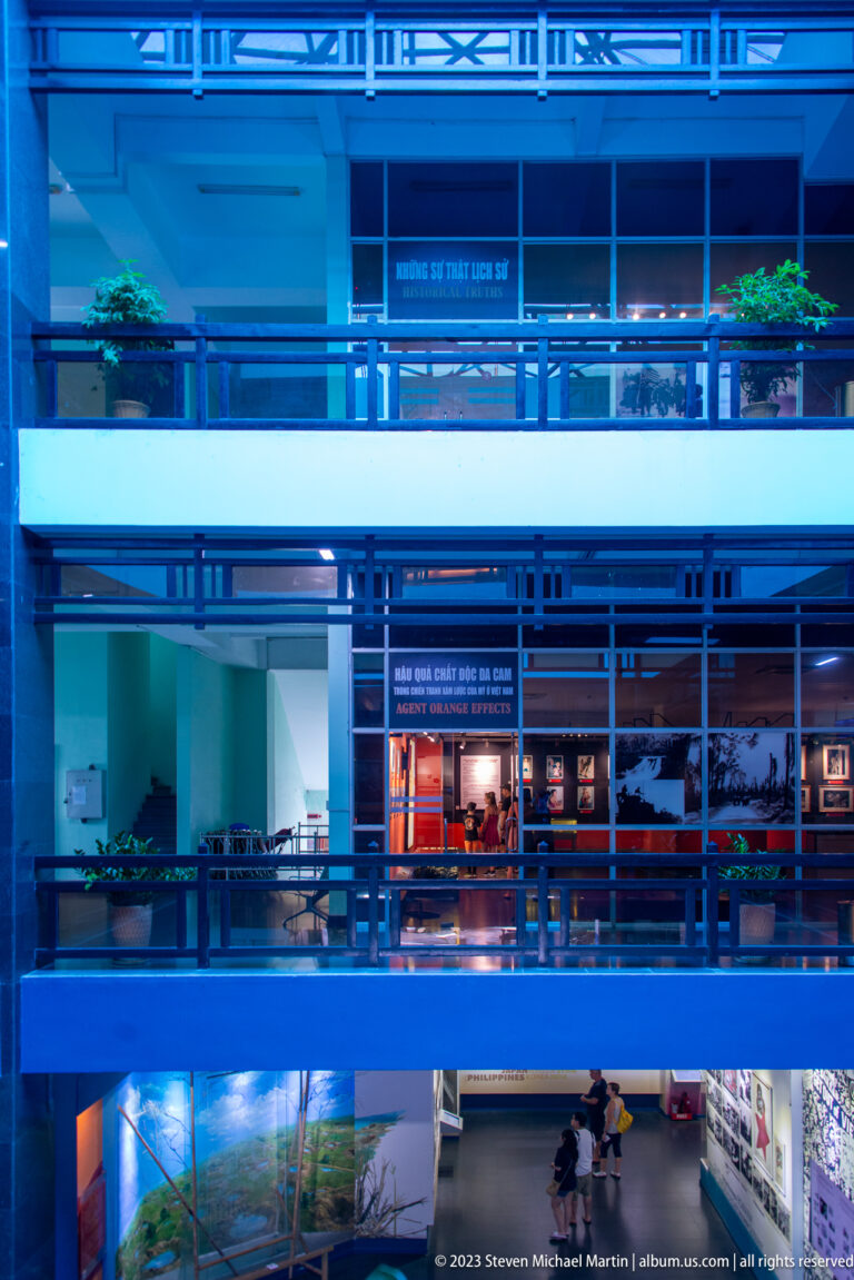 Blue multi-level museum atrium with balconies and gallery entrances.