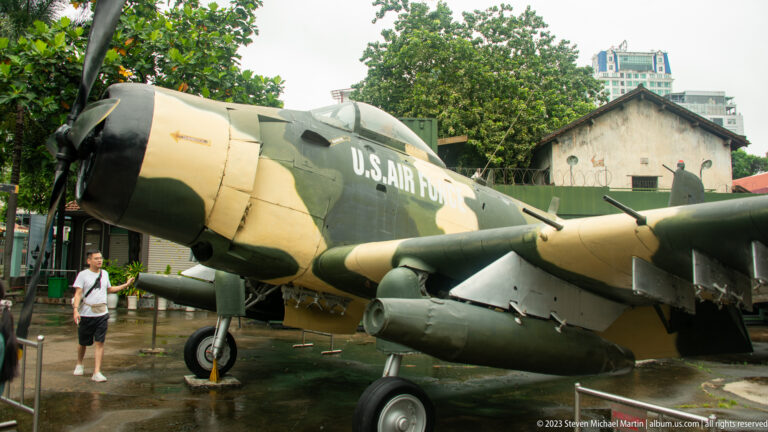 Camouflaged U.S. Air Force A-1 Skyraider with underwing stores on display.