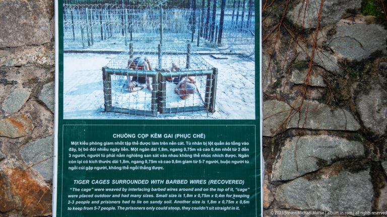 Bilingual tiger-cage panel with a photograph and descriptive text.