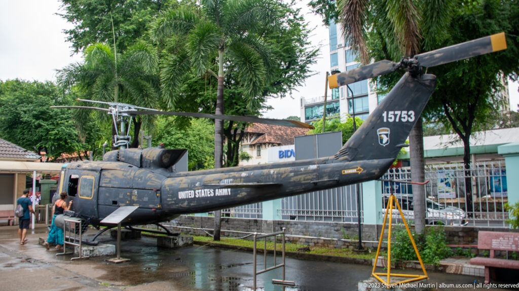 Weathered U.S. Army Huey helicopter viewed from the rear-left side.