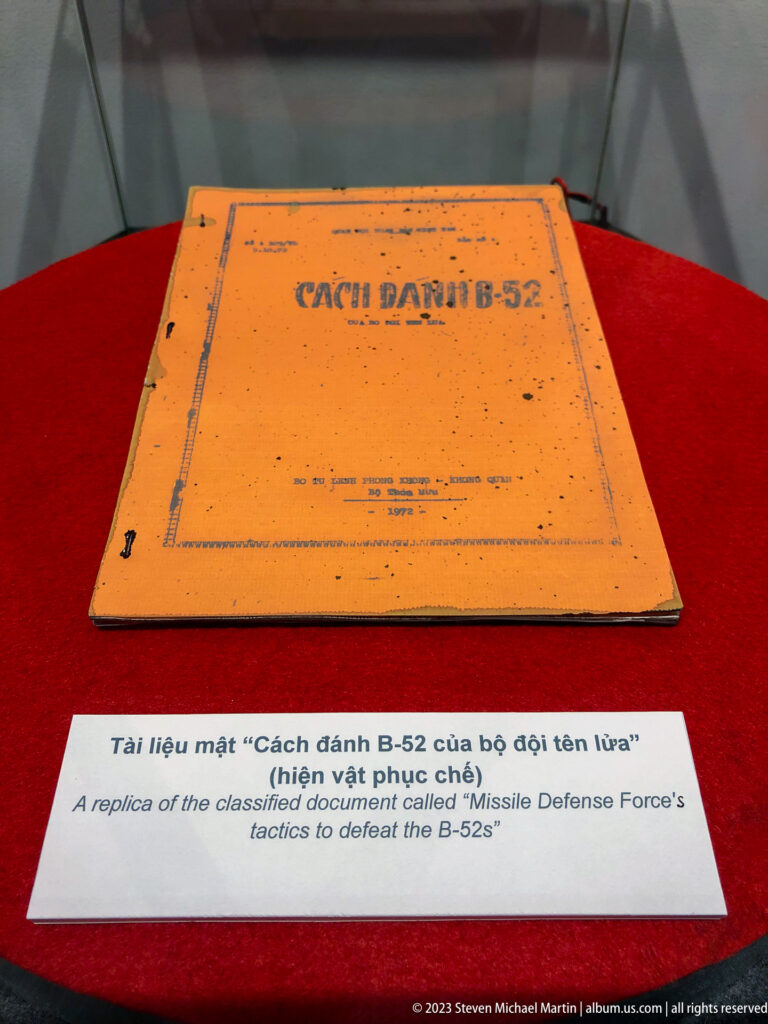 Orange booklet titled “Cách đánh B-52” above a bilingual museum label.