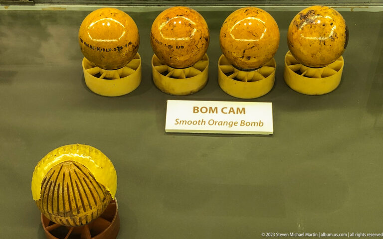 Yellow spherical bomblets with one opened example showing its interior.