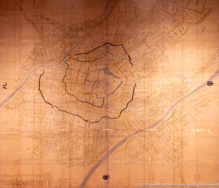 Historic map with the Kanazawa Castle enclosure outlined amid surrounding streets, waterways, and urban districts.