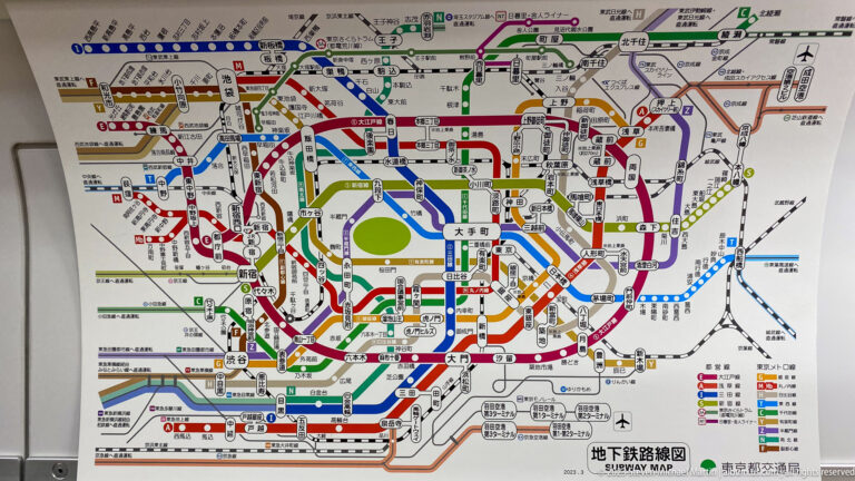 Large Tokyo subway map with many color-coded lines, station names, and a green central area.