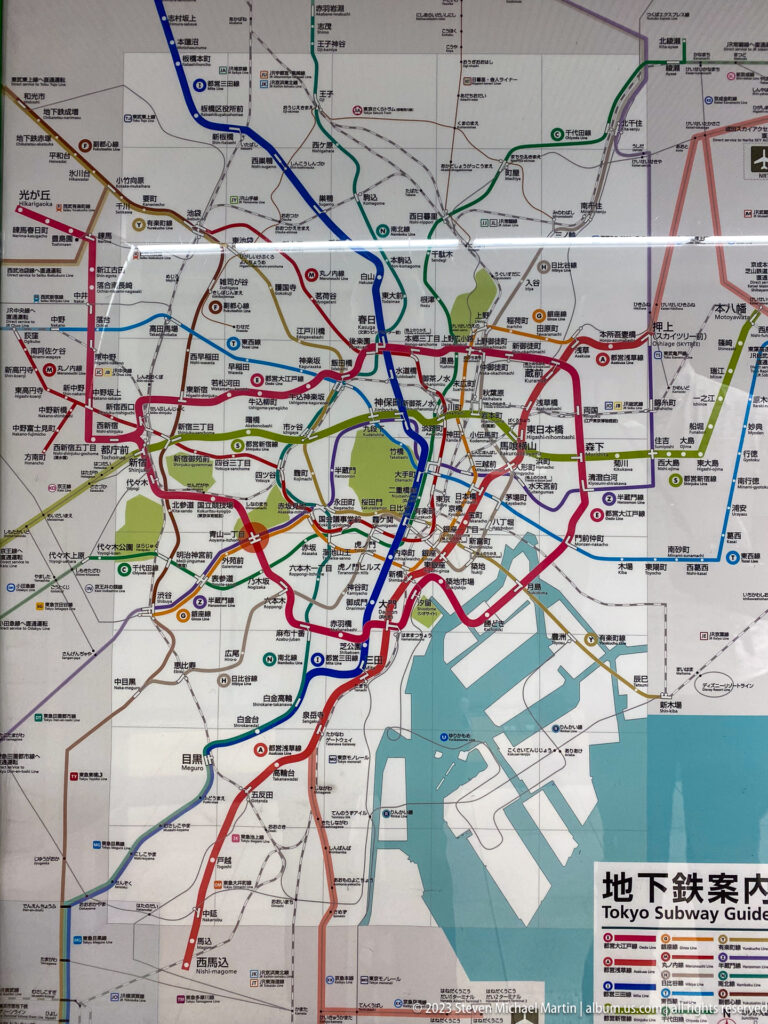 Tokyo rail map overlaid on city geography, waterways, parks, and waterfront districts.