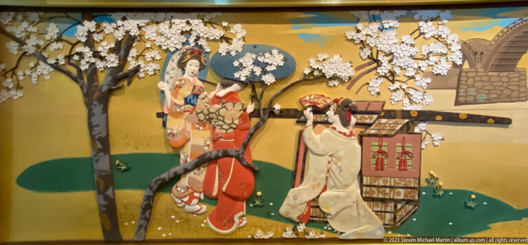 Women in ornate kimono, attendants, and a rickshaw move beneath flowering cherry trees in a gold-ground spring scene.