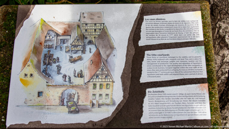 Multilingual interpretive panel with watercolor courtyard reconstruction and English heading “The little courtyards.”