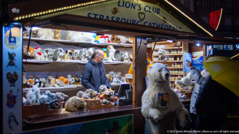 Lions Club Strasbourg Cathédrale stall filled with plush animals and a large white bear at the counter.
