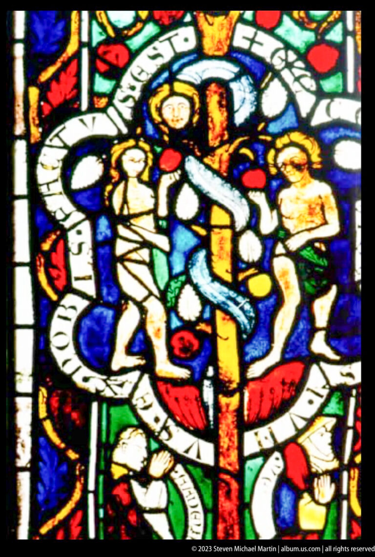 Colorful medieval stained-glass medallion with several robed figures around a central figure and an encircling inscription band.