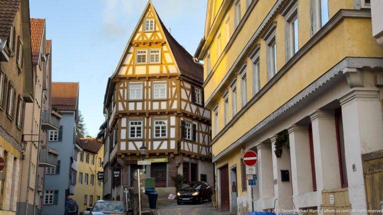 Narrow ochre-and-white half-timbered gabled house at the end of a tight street in Esslingen.