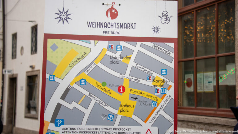Freiburg Christmas Market map showing Rathausplatz, Kartoffelmarkt, Unterlindenplatz, surrounding streets, and visitor symbols.