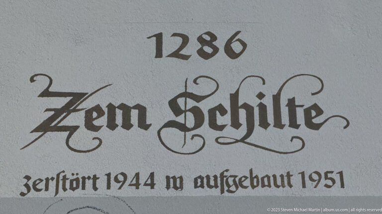 Painted German inscription reading 1280 and noting destruction in 1944 and rebuilding in 1951.