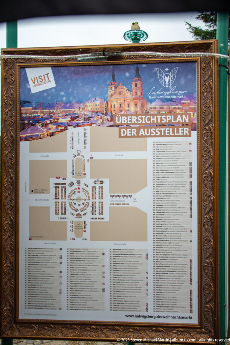Framed German exhibitor map for the Ludwigsburg Christmas market with stall diagram, numbered vendor lists, and festive banner.