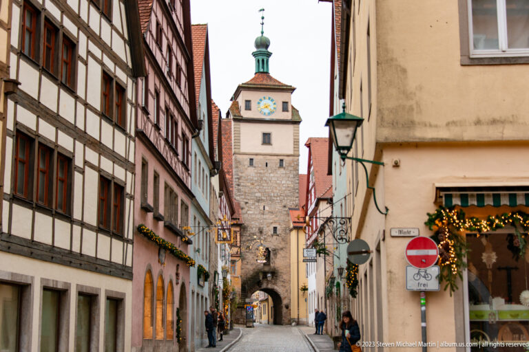 Long historic street lined with half-timbered and plastered buildings leading directly to Markusturm and its arched passage.