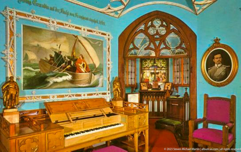 Piano beneath a maritime mural beside a pointed stained-glass window, portrait, and magenta chair in a blue historic room.