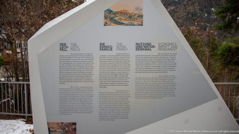 Outdoor interpretive panel with headings “The Facts,” “The Economics,” and “The Management,” plus historical illustrations.