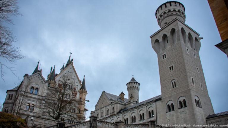 Low-angle view of Neuschwanstein's Palas and tall cylindrical tower rising above the inner courtyard.