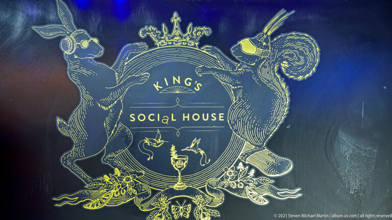 Gold King's Social House emblem with a crowned crest and illustrated animal figures on a dark background.
