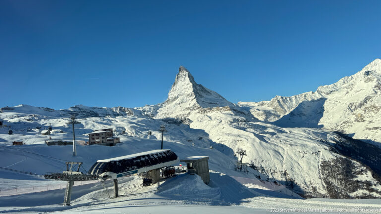 Matterhorn above snowy ski slopes with a low lift station, cables, and mountain infrastructure in the foreground.