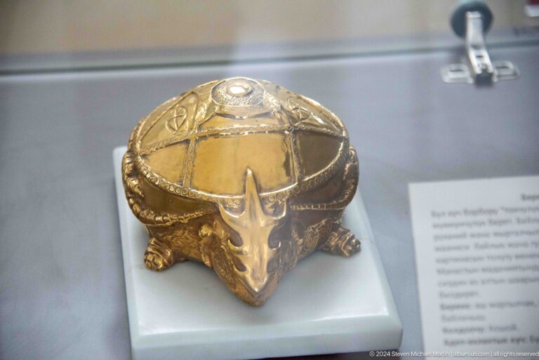 Gold helmet or headpiece in a display case.