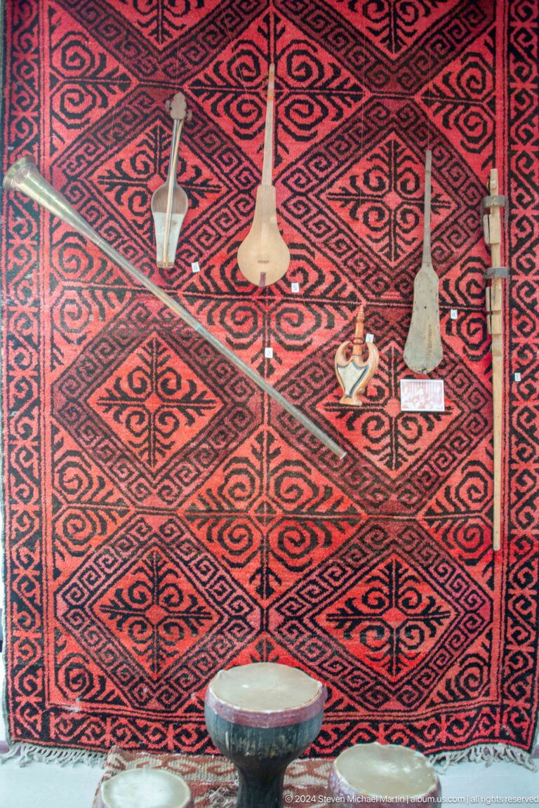 Red geometric carpet with small objects placed on it.