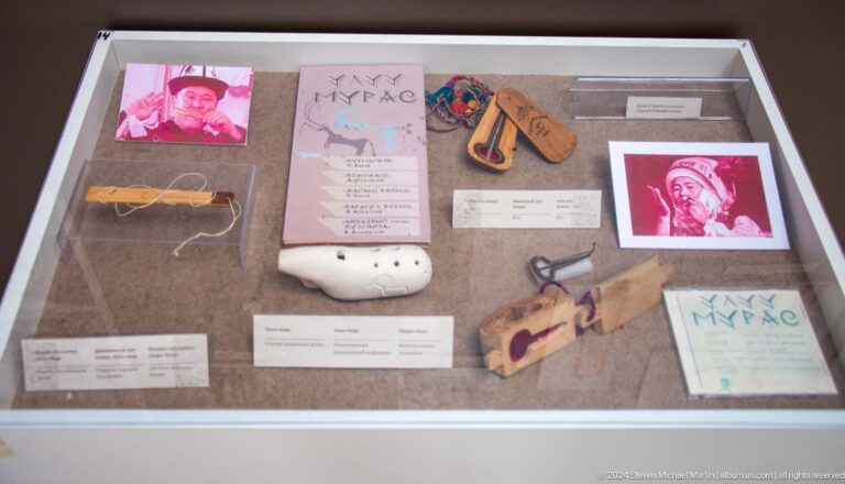 Museum case with photographs and small artifacts.