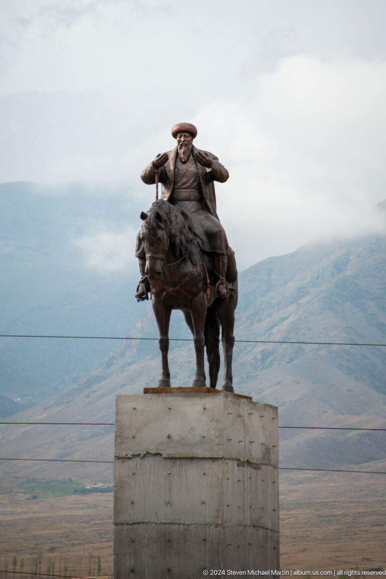 Equestrian statue against hazy mountains.