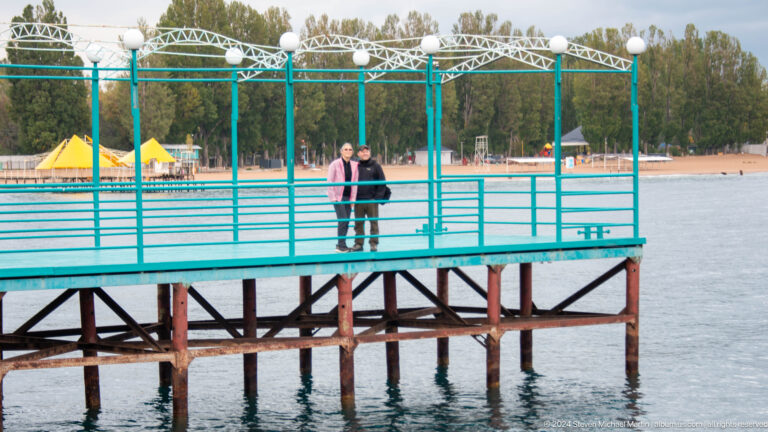 Two people standing on a raised lakeside platform.
