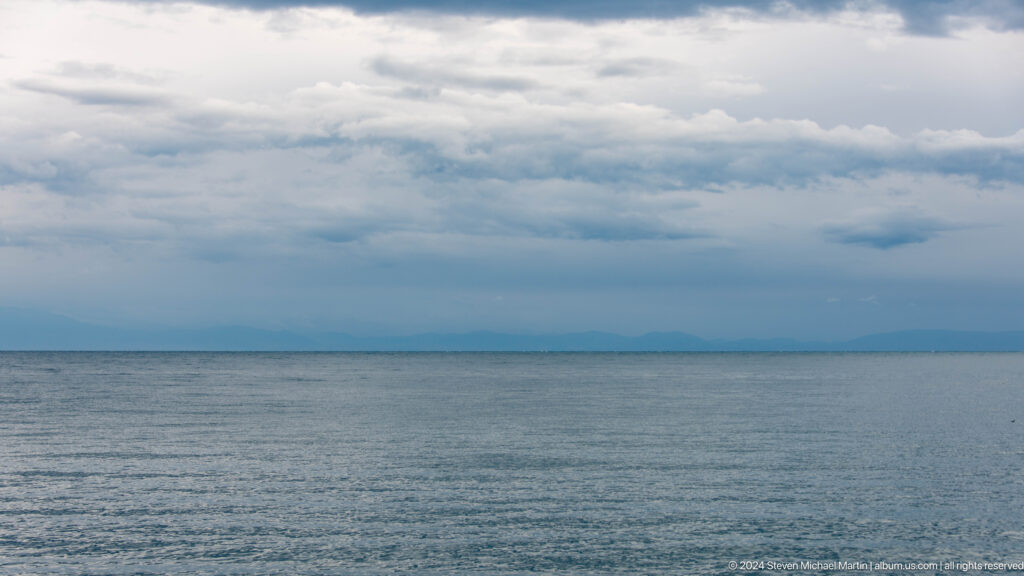 Calm open water beneath gray clouds.