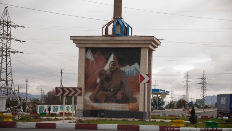 Roadside monument with painted horseman panel.