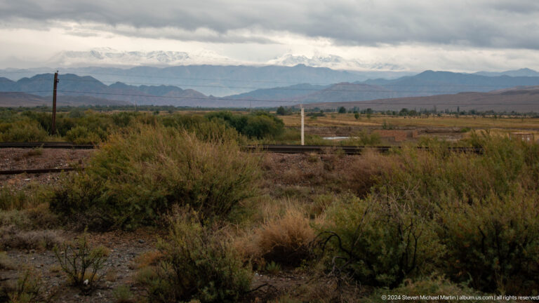 Scrubby foreground and distant mountain ridge.