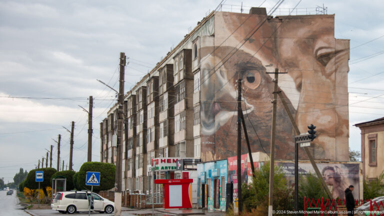 Long building with large eye mural.