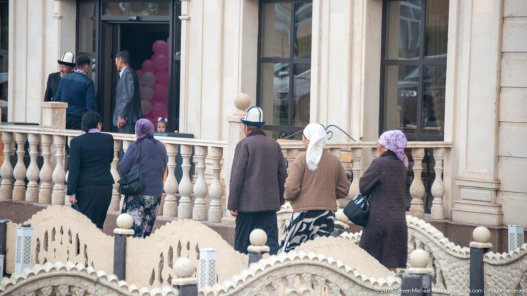 Older residents ascending ornate exterior stairs.