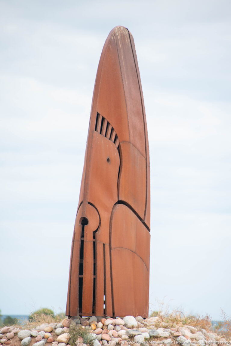 Tall carved wooden or metal sculptural panel.