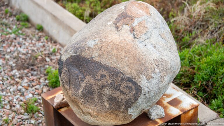 Rounded stone carved with an animal image.