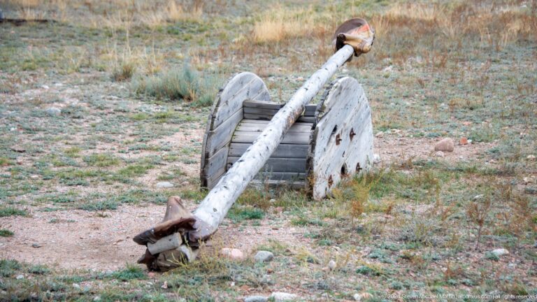 Weathered wooden wheel and beam installation.
