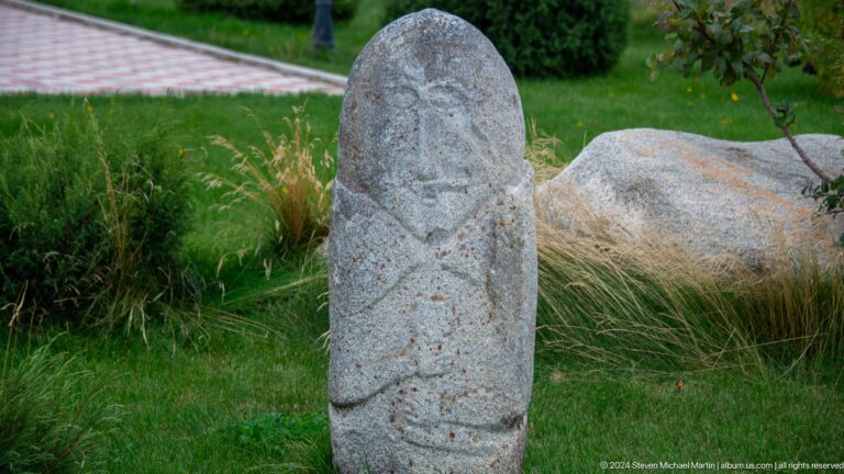 Tall weathered anthropomorphic stone marker.