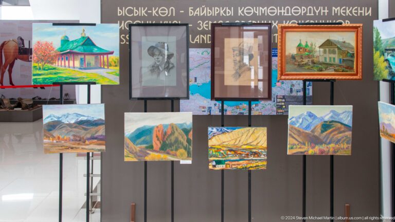 Framed paintings arranged beneath a banner.