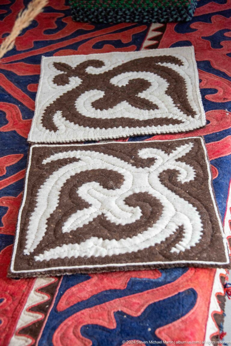 Brown-and-white felt rug with curling motif.