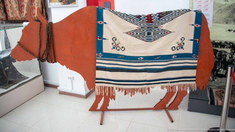 White textile panel with blue and black ornament.