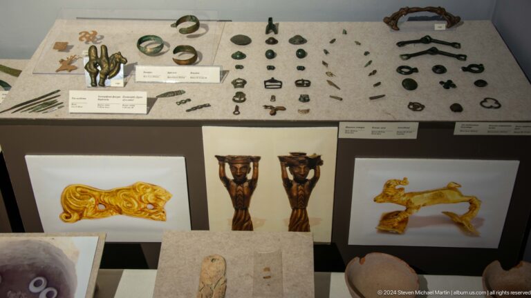 Museum case containing small metal artifacts.